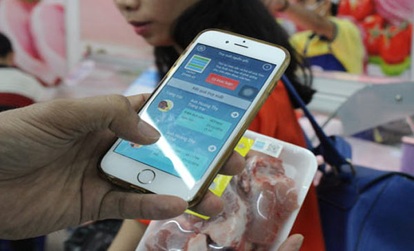 Người tiêu dùng sử dụng điện thoại thông minh để truy xuất nguồn gốc thịt heo trước khi mua. Ảnh: T.Hq Người tiêu dùng sử dụng điện thoại thông minh để truy xuất nguồn gốc thịt heo trước khi mua. Ảnh: T.H