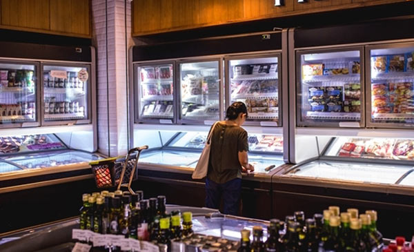 Một người phụ nữ đang cân nhắc mua hàng tại quầy đông lạnh một cửa hàng tạp hóa tại TP.HCM. Ảnh: Bloomberg. Một người phụ nữ đang cân nhắc mua hàng tại quầy đông lạnh một cửa hàng tạp hóa tại TP.HCM. Ảnh: Bloomberg.